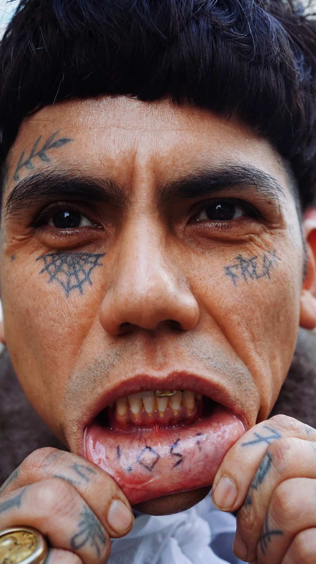 Close-up documentary portrait of a man with facial tattoos